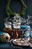 Vintage winter arrangement of two jars of honey decorated with old ribbons