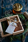 Honigglas mit Anhänger in einer Holzkiste als Weihnachtsgeschenk