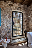 Glastür mit Sichtschutz im rustikalen italienischen Steinhaus