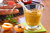 Homemade apricot mustard with grilled sausages