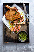 Beef steak with herb sauce on a baking tray