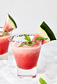 Watermelon margarita garnished with fresh mint leaves and watermelon slice