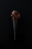 Dark chocolate with raspberry ice cream on a charcoal cone.