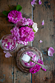 Pinkfarbene Rosenblüten mit Zucker im Schraubglas
