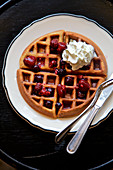 Home made waffle with berries and whipped cream