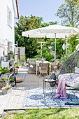 Summer terrace with hanging chair and parasol