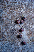 Damsons on a grey stone surface
