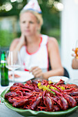 Crayfish on plate, woman on background, Stockholm, Sweden