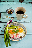 A fried eggs in a plate, served with fresh vegetables and coffee