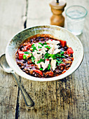 Mexican bean soup with shredded chicken and lime