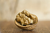 An open walnut with a shell on a wooden table