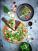 Wholegrain pizza with ham, mozzarella, vegetables and rocket