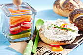 A vegetarian poppy seed roll with herb spread and vegetables