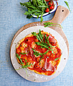 A tomato, ham and rocket pizza