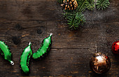 Weihnachtskugeln, Zapfen und Tannenzweige auf Holzuntergrund