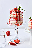 Small strawberry pavlova, drizzled with strawberry sauce
