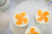 Sponge cakes topped with cream cheese and mandarins