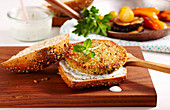 A vegetarian quinoa burger with yoghurt sauce and roasted vegetables