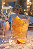 Cocktail with oranges in a cut glass on a Christmas table