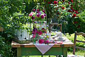 Etagere mit kleinen Sträußen aus Rosen, Wiesenkerbel, Witwenblume, Frauenmantel und Lupine als Tischdekoration
