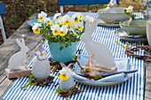 Easter table decoration with horned violets 'Rocky Sunny Side Up', willow wreaths and Easter bunnies