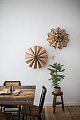Decorations handmade from brown paper on wall above tiny fir tree in dining room