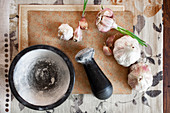 Garlic bulbs, garlic cloves and mortar and pestle