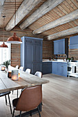 Esstisch in der Landhausküche mit blauen Fronten im Blockhaus