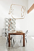 Various designer chairs at the wooden table under the light object