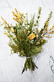 White and yellow bouquet of tulips, yellow berries, delphiniums and branches of mimosa