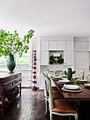 Cottage-style eat-in kitchen with dining table and green antique upholstered chairs