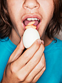 Teenager isst gekochtes Ei
