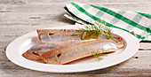 Smoked herring fillets with dill on an oval plate