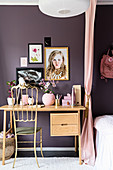 Goldener Stuhl am Schreibtisch vor violetter Wand im Kinderzimmer