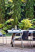 Chairs at the table on the terrace in the summer garden