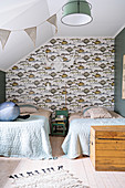 Twin beds and fish-patterned wallpaper in bedroom