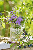 Late summer bouquet with Blue billygoat weed in glass jar with lace trim