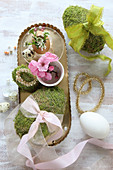Moss eggs with ribbons and gold and pink Easter decorations
