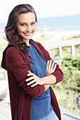A young brunette woman wearing a blue t-shirt and a wine red cardigan
