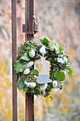 Easter wreath wrapped in moss, hay, and ivy, decorated with quail eggs, chicken feathers, and a wooden rabbit figure