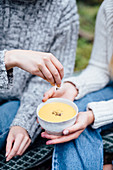 Frauen essen Suppe beim Picknick