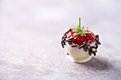 A strawberry with chocolate coating and chocolate sprinkles