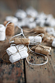 Kleine Geschenke in weiß und hellbraun auf Holz