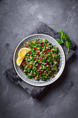 Tabbouleh salad on plate, rustic concrete background