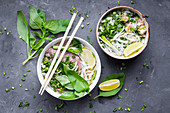 Traditional vietnamese noodle soups pho in bowls on concrete background