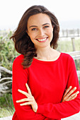 A young brunette woman wearing a red jumper