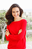 A young brunette woman wearing a red jumper
