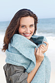 A young brunette woman wearing a grey windbreaker and a woollen shawl