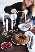 Junge Frau bereitet Zuckerglasur für Napfkuchen vor