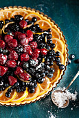 Berry and citrus tart dusted with powdered sugar